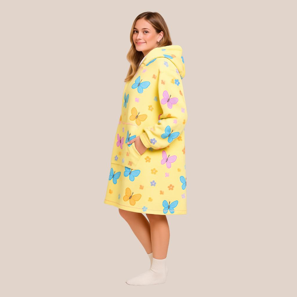 Side view of the Butterfly Dream wearable blanket with hands in pockets, showcasing colorful butterfly print.  