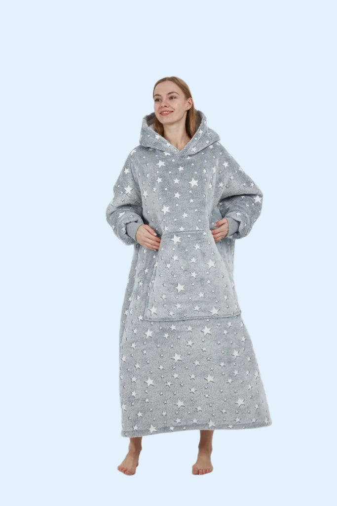 Model turning back with a soft smile in a grey wearable blanket hoodie with star design.